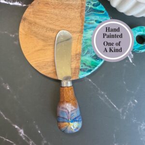 Round wooden board with blue hand-painted design and matching spreader with wooden handle.