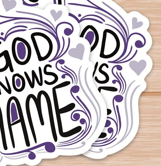 Stack of decorative stickers with My God knows my name text and purple heart designs on wood.