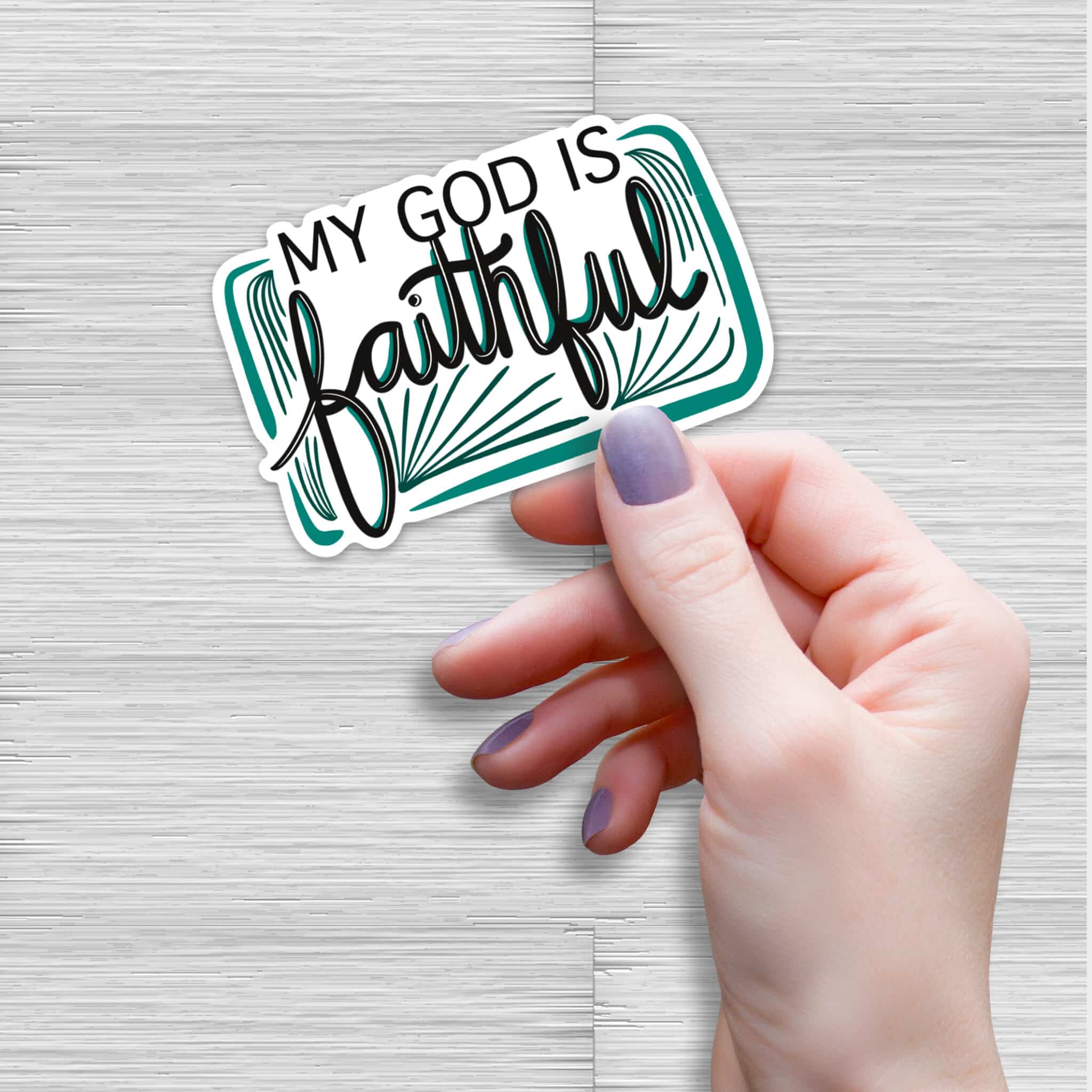 Hand holding a “My God Is Faithful” Christian vinyl sticker with black calligraphy and teal frame design, waterproof faith sticker for journals, laptops, and bottles.